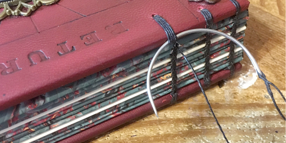 Coptic stitching technique for leather books. Shown with curved needle and linen thread.