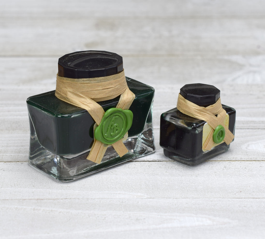 Two glass bottles of green ink