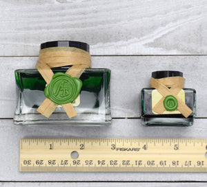 Ink bottles by ruler for scale